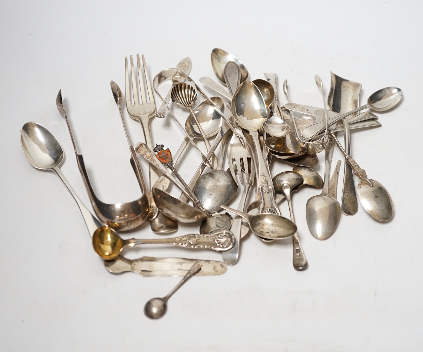 A small quantity of assorted 19th century and later silver flatware, two white metal spoons and a Victorian 'Rum' wine label, 18.2oz.